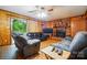 Comfortable living room featuring wood paneling, a brick fireplace, and a sliding glass door at 422 Sherrill Farm Rd, Lincolnton, NC 28092