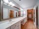 Bright bathroom featuring double sinks, large mirror, and separate walk-in closets at 4754 Polo Gate Blvd, Charlotte, NC 28216