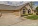 Exterior of a house featuring a two car garage, stone, and manicured landscaping at 4754 Polo Gate Blvd, Charlotte, NC 28216