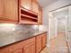 Bright kitchen featuring wood cabinets, stone backsplash, wine rack and woodgrain tile flooring at 4754 Polo Gate Blvd, Charlotte, NC 28216