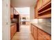 Open kitchen with wood cabinets, stone backsplash, stainless appliances and woodgrain tile floor at 4754 Polo Gate Blvd, Charlotte, NC 28216