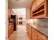Open kitchen with wood cabinets, stone backsplash, stainless appliances and woodgrain tile floor at 4754 Polo Gate Blvd, Charlotte, NC 28216