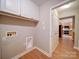 Bright laundry room featuring white cabinets and washer hookups on woodgrain tile floor at 4754 Polo Gate Blvd, Charlotte, NC 28216