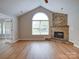 Bright living room features vaulted ceiling, fireplace with stone surround and large window at 4754 Polo Gate Blvd, Charlotte, NC 28216