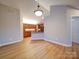Open-concept living room with view to the kitchen, featuring neutral walls and wood-look flooring at 4754 Polo Gate Blvd, Charlotte, NC 28216