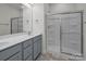 Modern bathroom features a double vanity with gray cabinets and a walk-in shower with sliding glass doors at 5103 Shasta St # 5103, Gastonia, NC 28052