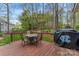 Relax on the wooden back deck with outdoor dining and views of the fenced backyard and surrounding trees at 5225 Mcchesney Dr, Charlotte, NC 28269