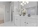 Bright bathroom features double vanity with white countertops and cabinets, decorative flower and large mirror at 5225 Mcchesney Dr, Charlotte, NC 28269