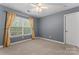 Bedroom with gray walls and beige carpet features a ceiling fan and a window with curtains at 5225 Mcchesney Dr, Charlotte, NC 28269