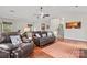 Bright bonus room featuring hardwood floors, staircase access, and cozy seating, ideal for entertainment or exercise at 5225 Mcchesney Dr, Charlotte, NC 28269