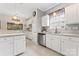 Well-appointed kitchen with white cabinets, stainless steel dishwasher, ample counter space and large windows at 5225 Mcchesney Dr, Charlotte, NC 28269