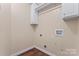 Neutral laundry room features wood floor, built in upper cabinets, and washer/dryer hookups at 5225 Mcchesney Dr, Charlotte, NC 28269