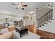 Open-concept living space with hardwood floors, staircase, and a view of the kitchen area with bar seating at 5225 Mcchesney Dr, Charlotte, NC 28269