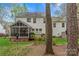The back of the home features a deck, screened-in porch, and lush greenery, offering privacy and charm at 5225 Mcchesney Dr, Charlotte, NC 28269