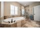 The bathroom features a soaking tub, a separate glass enclosed shower, and stone tile at 615 Reliance Ct, Tega Cay, SC 29708