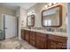The primary bathroom has double vanity sinks, granite countertops and framed mirrors at 615 Reliance Ct, Tega Cay, SC 29708
