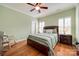 Bedroom with hardwood floors, rocking chair, and soothing green walls and matching bedding at 615 Reliance Ct, Tega Cay, SC 29708