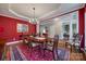 Elegant dining room with red accent wall, hardwood floors, and tray ceiling at 615 Reliance Ct, Tega Cay, SC 29708
