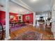 Elegant dining room featuring rich red walls, hardwood floors, and stylish chandelier at 615 Reliance Ct, Tega Cay, SC 29708