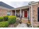 Inviting front porch with classic columns and red door surrounded by lush greenery at 615 Reliance Ct, Tega Cay, SC 29708
