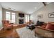 Cozy living room with a stone fireplace, hardwood floors, and large windows for natural light at 615 Reliance Ct, Tega Cay, SC 29708