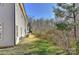 A view of the side yard showing grass, trees, and the side of the house at 6512 Quarterbridge Ln, Charlotte, NC 28262
