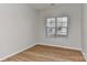 Well-lit bedroom featuring wood floors, a window with blinds, and neutral colored walls at 6512 Quarterbridge Ln, Charlotte, NC 28262