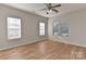 This spacious bedroom features laminated floors, three windows, and a modern ceiling fan at 6512 Quarterbridge Ln, Charlotte, NC 28262