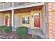 A ground floor entrance showcases a brick facade, a red front door, and manicured landscaping at 6512 Quarterbridge Ln, Charlotte, NC 28262
