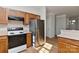 The kitchen features wooden cabinets, a stainless refrigerator, and laminate flooring at 6512 Quarterbridge Ln, Charlotte, NC 28262