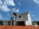 Charming two-story home with white siding, black shutters, and attached garage at 6707 Baker Creek Ave, Indian Land, SC 29707