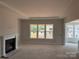 Spacious living room with fireplace, large windows and tray ceiling at 6707 Baker Creek Ave, Indian Land, SC 29707