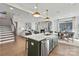 Open-concept living space with kitchen island, dining area, living room, and staircase at 6707 Baker Creek Ave, Indian Land, SC 29707