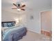 Cozy bedroom featuring ceiling fan, carpet, and queen bed with blue accent pillows and comforter at 7138 Dove Field Ln, Indian Land, SC 29707