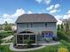 Back exterior view of home with patio, screened in porch, outdoor kitchen and fenced yard at 7138 Dove Field Ln, Indian Land, SC 29707