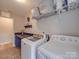 Well-lit laundry room featuring front loading washer and dryer and gray shelf with storage baskets at 7138 Dove Field Ln, Indian Land, SC 29707