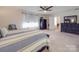 Bright main bedroom with neutral carpet, ceiling fan, dresser, and ensuite bathroom access at 7138 Dove Field Ln, Indian Land, SC 29707