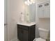Well-lit bathroom with a dark wood vanity, decorative cabinet, and a standard toilet at 8313 Balcony Bridge Rd, Huntersville, NC 28078