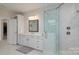 Bright bathroom with white cabinets, a large mirror, and a luxurious glass-enclosed shower at 8313 Balcony Bridge Rd, Huntersville, NC 28078