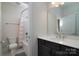 Cozy bathroom with a white countertop, dark cabinetry, and a shower-tub combo at 8313 Balcony Bridge Rd, Huntersville, NC 28078