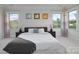 Serene bedroom with neutral tones, tray ceilings, and a large window overlooking backyard views at 8313 Balcony Bridge Rd, Huntersville, NC 28078