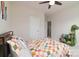 Bright bedroom with colorful quilt, ceiling fan, and quirky dinosaur-themed bookcase at 8313 Balcony Bridge Rd, Huntersville, NC 28078