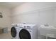 Functional laundry room equipped with a new washer, dryer, utility sink, and shelving at 8313 Balcony Bridge Rd, Huntersville, NC 28078