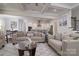 Open-concept living room with neutral decor, a coffered ceiling, and views of the kitchen and dining area for easy entertaining at 8313 Balcony Bridge Rd, Huntersville, NC 28078