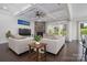Cozy living room features a stone fireplace, coffered ceiling, plush sofas, and a view of the green outdoors at 8313 Balcony Bridge Rd, Huntersville, NC 28078