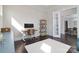 Bright home office features a modern desk, shelving unit, and a doorway leading to another room at 8313 Balcony Bridge Rd, Huntersville, NC 28078
