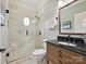Well lit bathroom with tiled shower, glass door, modern vanity, and dark countertop at 8623 Tullamore Park Cir, Charlotte, NC 28226