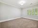 Bright bedroom features neutral walls, trim, carpet, and shuttered windows at 8623 Tullamore Park Cir, Charlotte, NC 28226