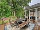 Wooden deck with dining area and outdoor seating overlooking a lush backyard and beautiful wooded area at 8623 Tullamore Park Cir, Charlotte, NC 28226