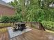 Outdoor deck with dining area providing a serene view of the backyard and surrounding greenery at 8623 Tullamore Park Cir, Charlotte, NC 28226